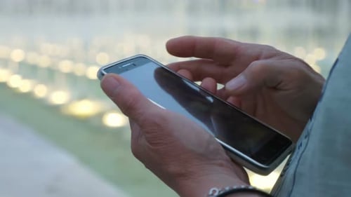 Nahaufnahme der Hand des Mannes mit Smartphone - im Freien