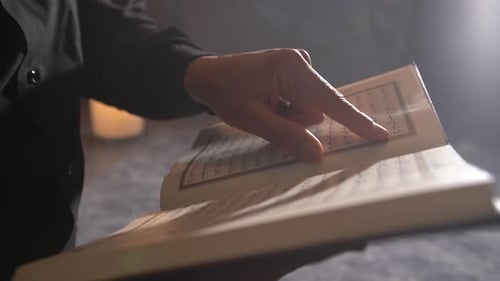 Hand umblätternde Koran-Seite.