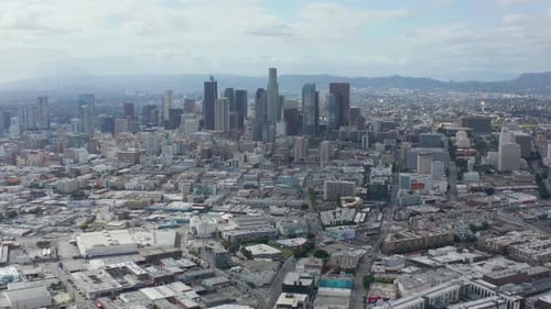 AERIAL: Slowly Circling Downtown Los Angeles Skyline with Warehouse Art District in Foreground with
