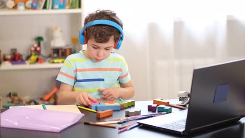 Young Boy Learning with Blocks at Desk