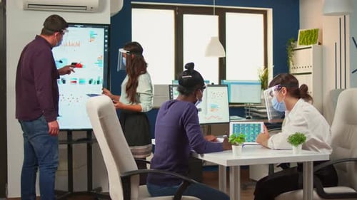 Team Collaborates in Modern Office with Face Shields