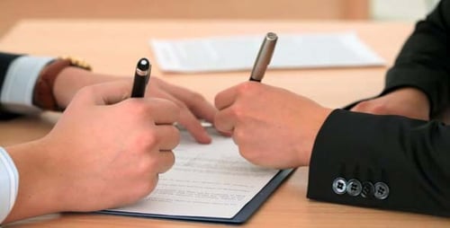 Two People Signing a Business Contract