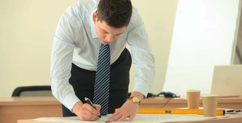 Young Adult Designs Technical Drawings in Bright Office