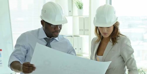 Architects Discussing Blueprints in Office Building