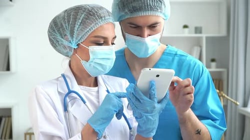 Team of Doctors Discuss Patients Diagnosis on Tablet in Clinic