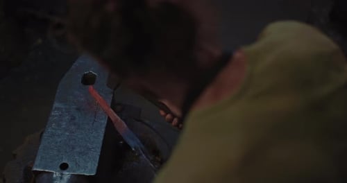 Blacksmith is Decorating Handle of Knife Hammering on Anvil View From Shoulder Prores