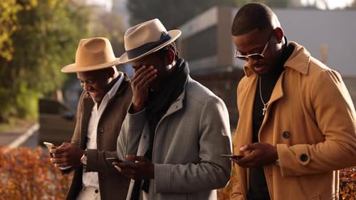 Three Stylish Men Using Phones in City