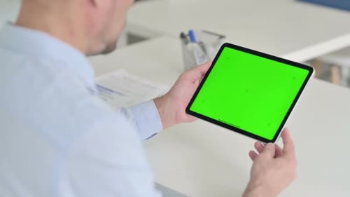 Middle Aged Man Using Tablet with Green Chroma Screen