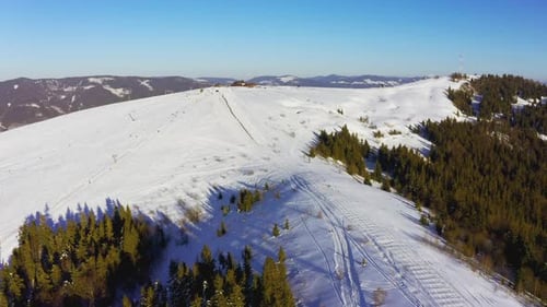Old Ski Station on a Snowy Mountain Slope with a Lot of People on Skis and Snowboards