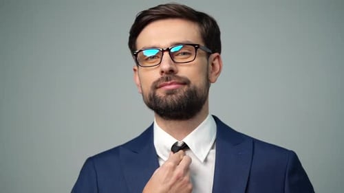 Man Adjusts Tie in Blue Suit, Portrait