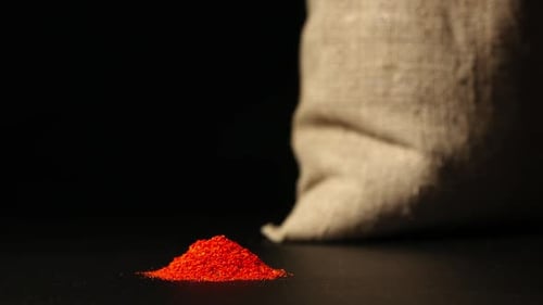 Montón de polvo de pimiento rojo que crece cerca de un saco