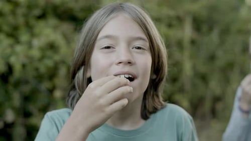Child Eating Food Outdoors in Close Up