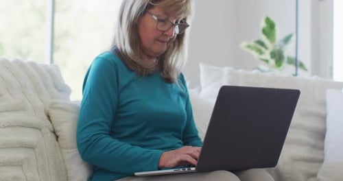 Woman Uses Laptop While Sitting on Couch