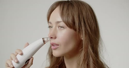 Beautiful Young Woman In Studio Using Pore Vacuum