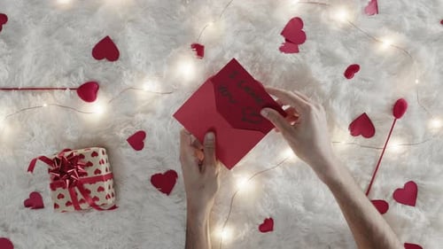 Hand Puts I Love You Card in Envelope
