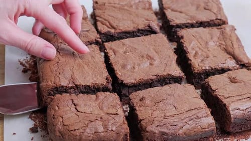 Freshly Baked Brownies Being Cut and Lifted