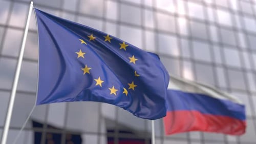 European Union and Russia Flags Waving in Front of Building