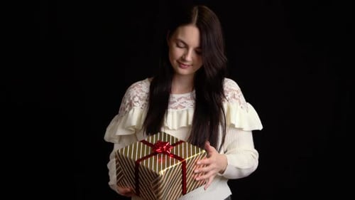 Young Woman Holds a Gold Gift Box