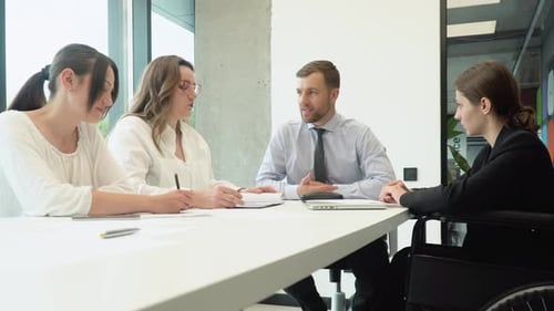 Diverse Group of Work Colleagues Talking at Office Meeting One in Wheelchair