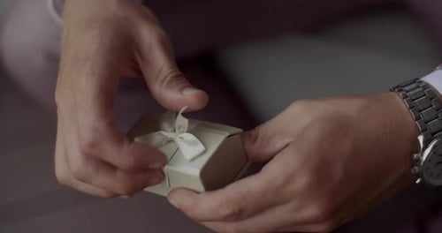 Close up of man hands hold a box with wedding rings