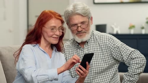 Senior Couple Relaxing at Home with Smartphone