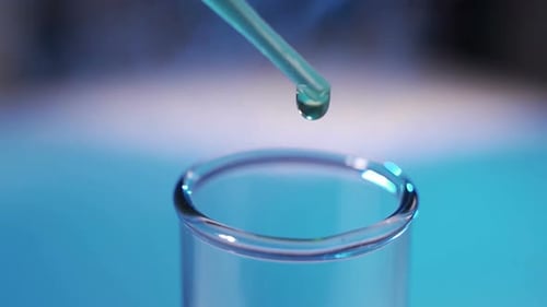 Liquid Dropping Into Test Tube in Laboratory