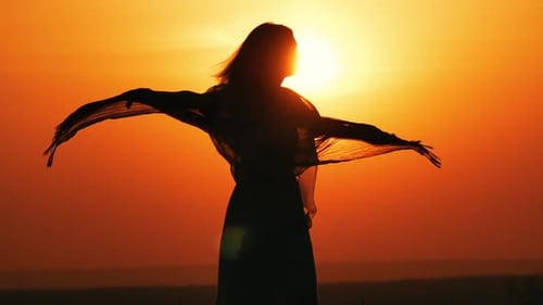 Woman Silhouette Enjoying Sunrise with Arms Outstretched