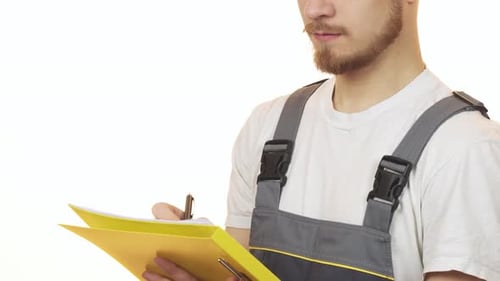 Cropped Shot of a Industry Worker Smiling Making Notes on Clipboard