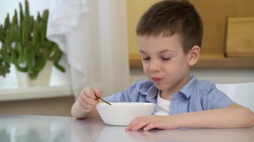 Child Eating a Meal at the Kitchen Table