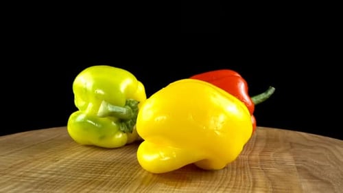 Fresh Peppers Rotating on a Wooden Surface