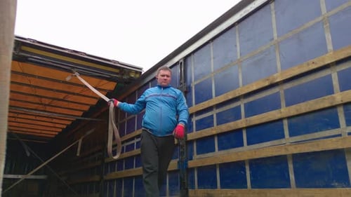 Man Holding Strap in Back of Blue Truck