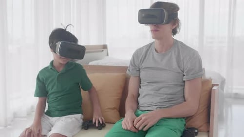 Father and Son Playing VR Games Together at Home