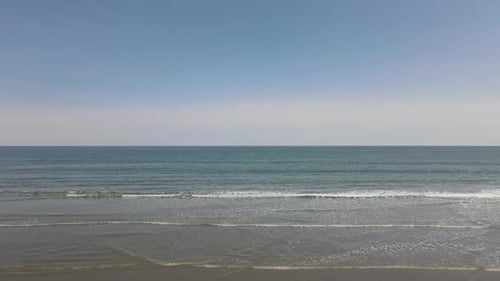 Drohne schiebt sich auf klarem, wolkenlosem und sonnigem Himmel über kleine Wellen zum offenen Atlantik