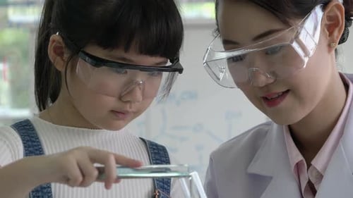 Girl and Woman Experimenting With Test Tubes in Lab