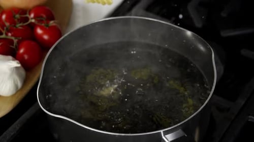 Adding Pasta to Boiling Water on Stove