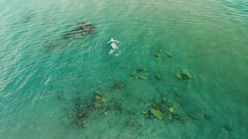 Aerial View of Young Woman Swimming in the Transparent Turquoise Sea Water