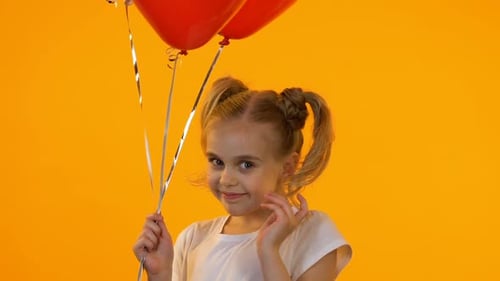 Little Girl Posing with Red Heart Balloons