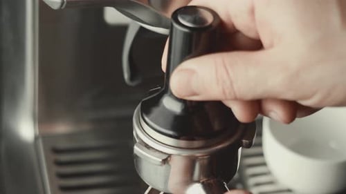 Grinder stopft gerösteten Kaffee aus der Kaffeemaschine