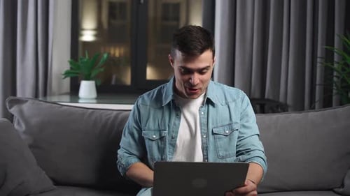 Young Adult Chatting on Laptop From Home at Night