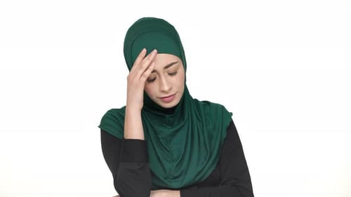 Stressed Woman Wearing Hijab with Hand on Forehead