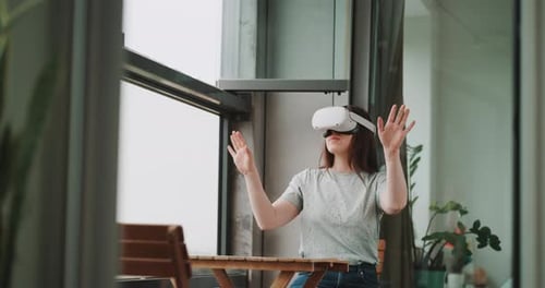 Young woman experiencing the metaverse wearing virtual reality goggles