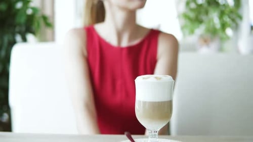 Young Adult in Red Dress with Latte