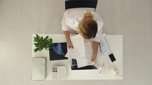 Young and Professional Doctor Working with Documents in the Medical Office