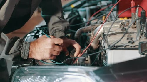 Man Works on Car Engine with Electronic Probe