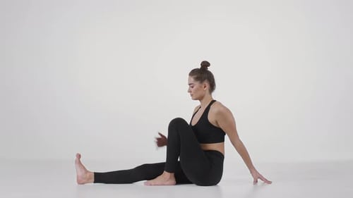 Woman Performs Seated Spinal Twist Stretch in Studio