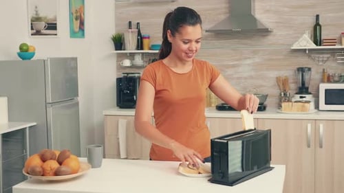 Woman Toasting Bread in Modern Home Kitchen