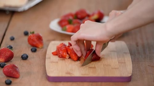 Woman Slicing Strawberry on Cutting Board Close Up