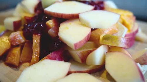 Rotating view of a pile of fresh fruit on a wooden board