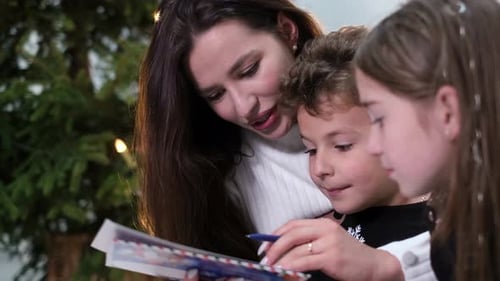 Mother and Children Write Letters by Christmas Tree