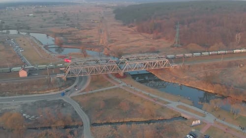 Aerial View of Train Crossing Bridge at Sunrise